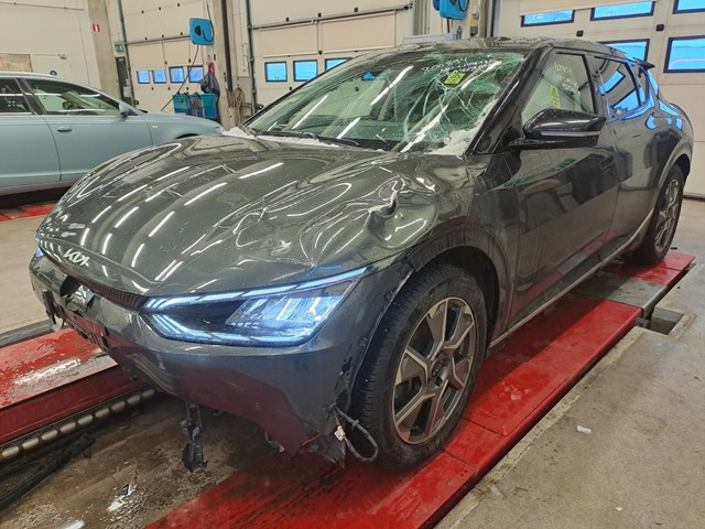 Auction photograph showing the Kia EV6 with roof and windscreen damage